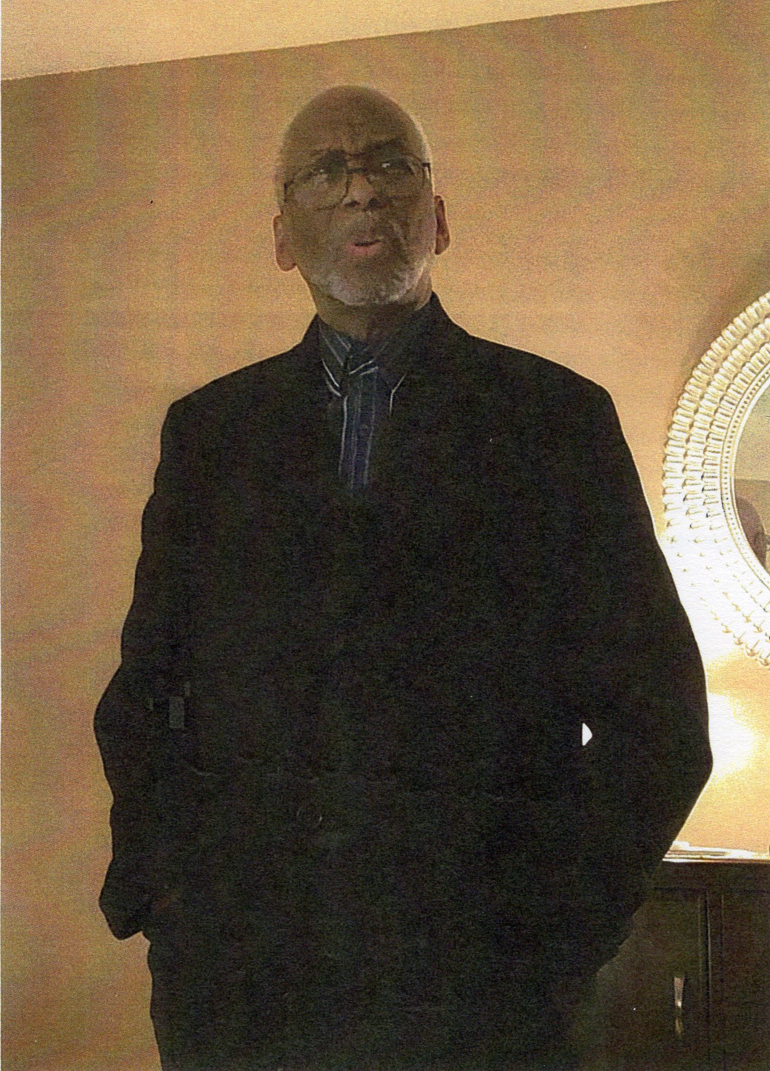 Photo of Curtis Jackson, Jr., standing in jacket and tie with hands in front pockets